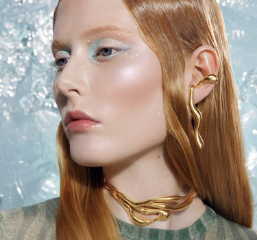 goldene flüssige ohrringe, die sich um das ohr legen