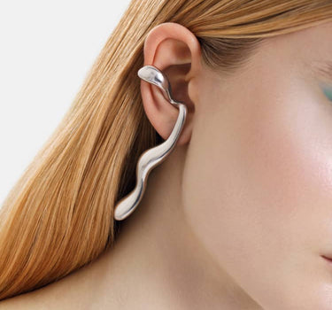 silberne flüssige ohrringe, die sich um das ohr legen
