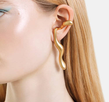 goldene flüssige ohrringe, die sich um das ohr legen